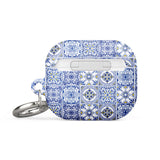 The Lisboa Azul for AirPods Gen 3 by Statement Cases features a rectangular silicon case adorned with a blue and white intricate tile pattern. It comes with a silver metal carabiner on one side, allowing for easy attachment to a bag or keychain, and offers impact-absorbing protection.