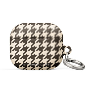 A close-up image of a houndstooth-patterned Timeless Houndstooth for AirPods Gen 3 case with a small keyring attached to its right side. The case features a classic black and white design and has the text "Statement Cases" printed on the bottom. It also includes a durable metal carabiner for secure attachment.