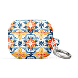 A rectangular AirPods case with a metal carabiner attachment, featuring an impact-absorbing design and a vibrant floral and geometric pattern in blue, orange, yellow, and white colors reminiscent of traditional tile designs. The brand name "Statement Cases" is printed on the bottom. This is the Mediterranean Bloom for AirPods Gen 3.