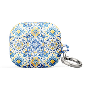 The Blue Mirage for AirPods Gen 3 by Statement Cases is a small rectangular case with rounded edges, adorned with a colorful and intricate tile pattern in blue, yellow, and white. Crafted from impact-absorbing material, the case includes a silver keyring attached to the right side.