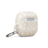 A Classic Nude for AirPods Gen 3 with white polka dots and a metal carabiner attached to the side. Crafted from a premium impact-absorbing material, the case features the text "Statement Cases" written at the bottom.