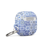 The Lisboa Azul for AirPods Gen 3 by Statement Cases features a rectangular silicon case adorned with a blue and white intricate tile pattern. It comes with a silver metal carabiner on one side, allowing for easy attachment to a bag or keychain, and offers impact-absorbing protection.