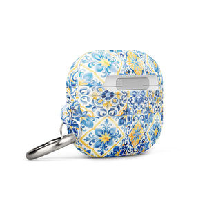 The Blue Mirage for AirPods Gen 3 by Statement Cases is a small rectangular case with rounded edges, adorned with a colorful and intricate tile pattern in blue, yellow, and white. Crafted from impact-absorbing material, the case includes a silver keyring attached to the right side.