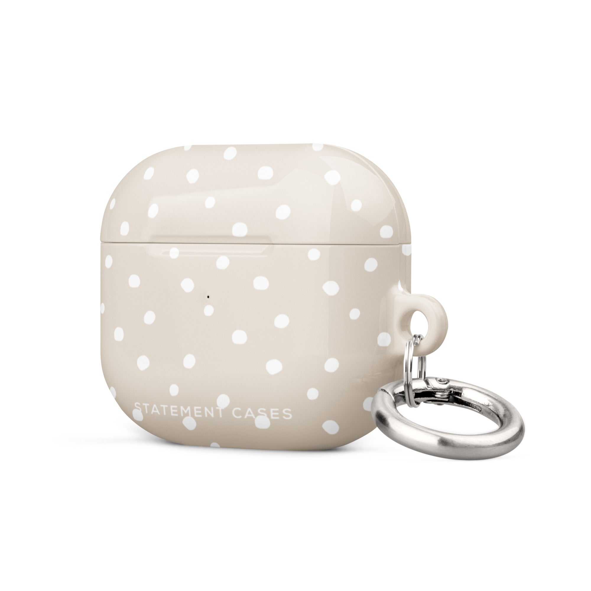 A Classic Nude for AirPods Gen 3 with white polka dots and a metal carabiner attached to the side. Crafted from a premium impact-absorbing material, the case features the text "Statement Cases" written at the bottom.