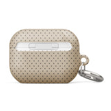 A beige Delicate Elegance for AirPods Pro Gen 2 with a black polka dot pattern. The case features impact-absorbing material for added protection and has a small metal loop on the left side attached to a silver keyring. The brand name "Statement Cases" is printed in white near the bottom.