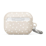 A beige Classic Nude for AirPods Pro Gen 2 case with white polka dots and a small metal carabiner attached to the side, displaying the brand text "Statement Cases.