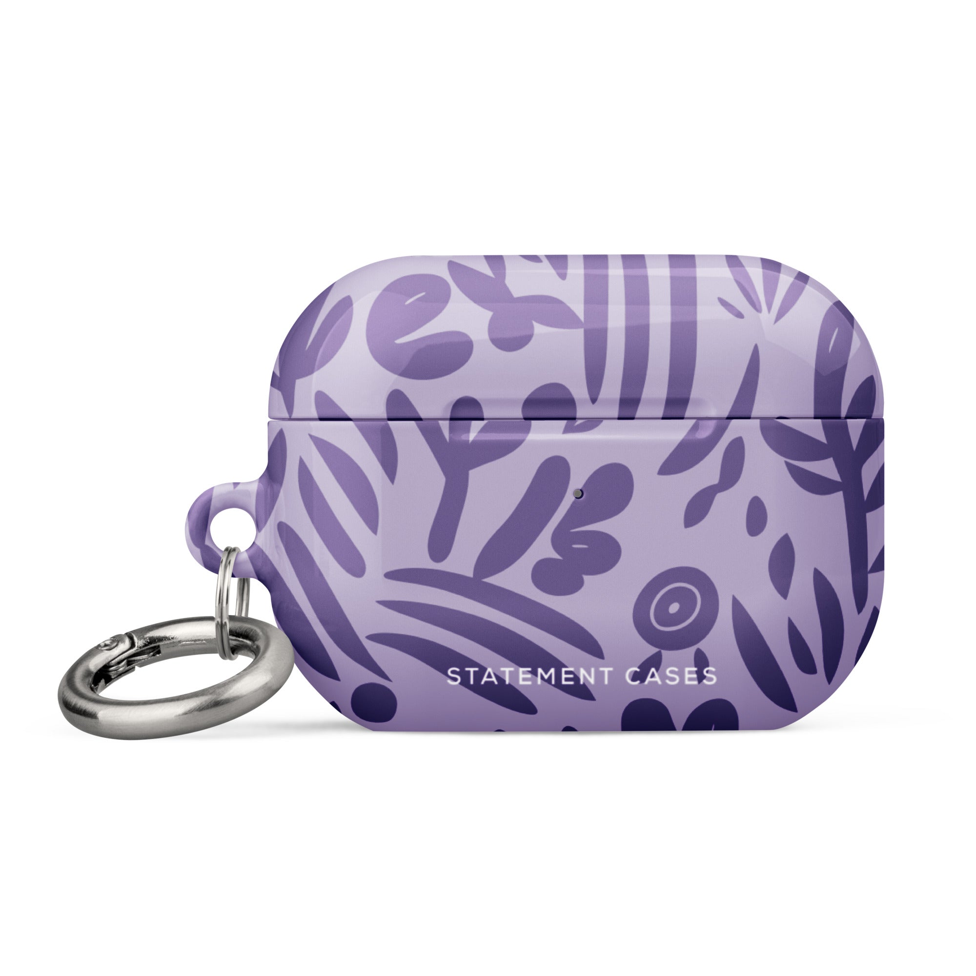 Introducing the Luna Morada for AirPods Pro Gen 2 by Statement Cases, a lavender hard shell case designed for wireless earbuds. Featuring an impact-absorbing property, this case boasts an abstract purple leaf pattern and the "STATEMENT CASES" logo on the front, complete with a metal carabiner for added convenience.