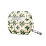 A Grand Estate Mosaic for AirPods Pro Gen 2 with a geometric pattern in shades of green, beige, and black. The design features overlapping circles and diamond shapes. A metal carabiner is attached to its left side for convenience. The brand "Statement Cases" is printed at the bottom.