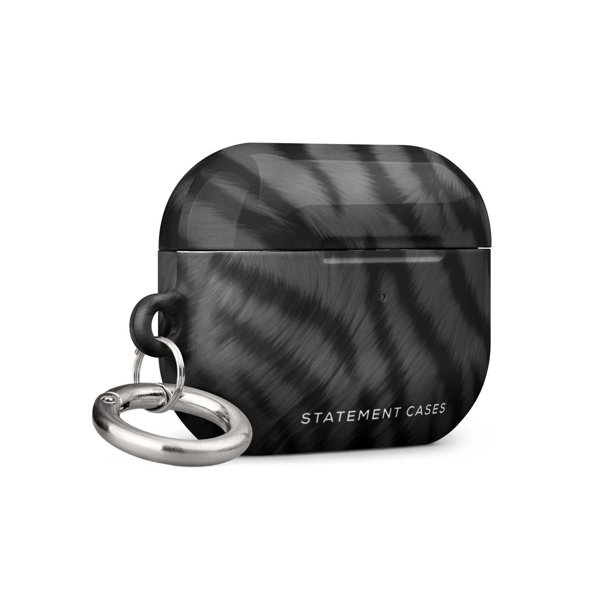 A black and gray patterned protective Charisma Tiger Fur for AirPods Pro Gen 2 case for wireless earbuds is shown against a white background. Crafted from premium impact-absorbing material, the case features a metallic carabiner keyring on the left side and the text "Statement Cases" at the bottom front.