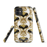 A protective iPhone 15 Pro Max case with a stylish design features an intricate gold and black baroque pattern. The camera lenses and logo branding "Statement Cases" are prominently visible.