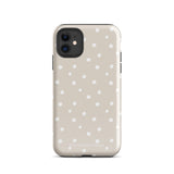 A beige Classic Nude for iPhone case with white polka dots, designed for the iPhone 15 Pro Max, covering the back of a phone with three visible camera lenses and one flash positioned at the upper left corner. This protective iPhone case features "Statement Cases" in small capital letters at the bottom.