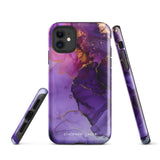 A Statement Cases Golden Orchid Marble for iPhone with a case featuring an abstract design of swirling purple, pink, and gold hues over a white background. The marbled patterns with metallic accents provide dual-layer protection and are impact-resistant. The top of the case has cutouts for the phone's camera lenses and is induction charging compatible.