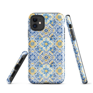 The Blue Mirage for iPhone by Statement Cases features a dual-layered, impact-resistant polycarbonate exterior with a TPU inner liner. Inspired by traditional Portuguese tiles, the blue and yellow patterned case boasts an intricate design of floral and geometric motifs. With its elegant and colorful appearance, the phone's camera is visible at the top left of the case.