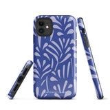 An iPhone encased in the "Mariposa Azul" by Statement Cases, featuring a blue design with an abstract white leaf pattern. The case combines curved and pointed shapes and provides dual-layer protection with TPU lining and impact-resistant polycarbonate. Camera lenses and other top elements remain unobstructed, and "Statement Cases" is inscribed at the bottom.