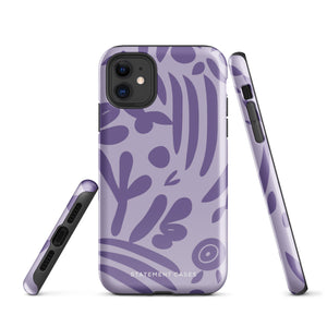 The Luna Morada for iPhone by Statement Cases is a durable phone case with a purple protective exterior featuring abstract dark purple and lavender patterns. The design includes geometric shapes and curves, giving it a modern artistic look. Made from impact-resistant polycarbonate, the lower part of the case prominently displays "STATEMENT CASES.