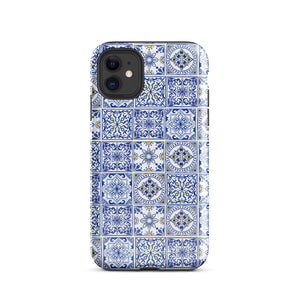 The Lisboa Azul for iPhone by Statement Cases is a smartphone adorned with a dual-layer protection phone case, featuring an intricate blue and white tile pattern. The design showcases various geometric and floral motifs, forming a visually appealing mosaic effect. The impact-resistant camera lenses and flash are prominently visible at the top left.