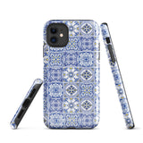 The Lisboa Azul for iPhone by Statement Cases is a smartphone adorned with a dual-layer protection phone case, featuring an intricate blue and white tile pattern. The design showcases various geometric and floral motifs, forming a visually appealing mosaic effect. The impact-resistant camera lenses and flash are prominently visible at the top left.