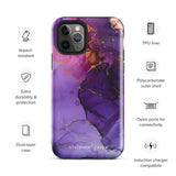 A Statement Cases Golden Orchid Marble for iPhone with a case featuring an abstract design of swirling purple, pink, and gold hues over a white background. The marbled patterns with metallic accents provide dual-layer protection and are impact-resistant. The top of the case has cutouts for the phone's camera lenses and is induction charging compatible.