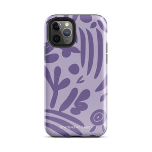 The Luna Morada for iPhone by Statement Cases is a durable phone case with a purple protective exterior featuring abstract dark purple and lavender patterns. The design includes geometric shapes and curves, giving it a modern artistic look. Made from impact-resistant polycarbonate, the lower part of the case prominently displays "STATEMENT CASES.