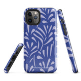 An iPhone encased in the "Mariposa Azul" by Statement Cases, featuring a blue design with an abstract white leaf pattern. The case combines curved and pointed shapes and provides dual-layer protection with TPU lining and impact-resistant polycarbonate. Camera lenses and other top elements remain unobstructed, and "Statement Cases" is inscribed at the bottom.