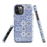 The Lisboa Azul for iPhone by Statement Cases is a smartphone adorned with a dual-layer protection phone case, featuring an intricate blue and white tile pattern. The design showcases various geometric and floral motifs, forming a visually appealing mosaic effect. The impact-resistant camera lenses and flash are prominently visible at the top left.