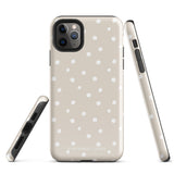 A beige Classic Nude for iPhone case with white polka dots, designed for the iPhone 15 Pro Max, covering the back of a phone with three visible camera lenses and one flash positioned at the upper left corner. This protective iPhone case features "Statement Cases" in small capital letters at the bottom.