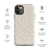 A beige Classic Nude for iPhone case with white polka dots, designed for the iPhone 15 Pro Max, covering the back of a phone with three visible camera lenses and one flash positioned at the upper left corner. This protective iPhone case features "Statement Cases" in small capital letters at the bottom.