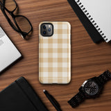 A Gingham Grace for iPhone by Statement Cases is covered with a protective case featuring a beige and white checkered pattern. The case's design includes a matte finish, dual-layer protection with an impact-resistant polycarbonate exterior and TPU lining, and the text "Statement Cases" printed near the bottom. The phone's cameras and buttons are visible.