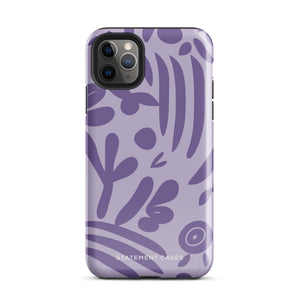 The Luna Morada for iPhone by Statement Cases is a durable phone case with a purple protective exterior featuring abstract dark purple and lavender patterns. The design includes geometric shapes and curves, giving it a modern artistic look. Made from impact-resistant polycarbonate, the lower part of the case prominently displays "STATEMENT CASES.