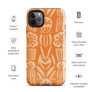 A Savannah Ardiente for iPhone from Statement Cases, featuring a dual-layered phone case in orange with a floral pattern showcasing cream-colored flowers, leaves, and geometric shapes. This impact-resistant polycarbonate case displays "STATEMENT CASES" at the bottom and reveals the camera lenses at the top left corner.