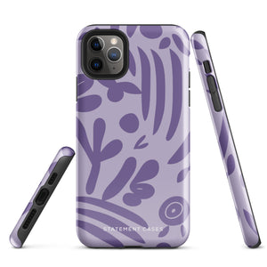 The Luna Morada for iPhone by Statement Cases is a durable phone case with a purple protective exterior featuring abstract dark purple and lavender patterns. The design includes geometric shapes and curves, giving it a modern artistic look. Made from impact-resistant polycarbonate, the lower part of the case prominently displays "STATEMENT CASES.