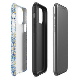 The Blue Mirage for iPhone by Statement Cases features a dual-layered, impact-resistant polycarbonate exterior with a TPU inner liner. Inspired by traditional Portuguese tiles, the blue and yellow patterned case boasts an intricate design of floral and geometric motifs. With its elegant and colorful appearance, the phone's camera is visible at the top left of the case.