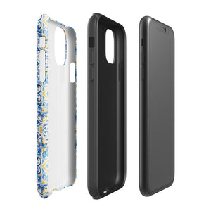 The Blue Mirage for iPhone by Statement Cases features a dual-layered, impact-resistant polycarbonate exterior with a TPU inner liner. Inspired by traditional Portuguese tiles, the blue and yellow patterned case boasts an intricate design of floral and geometric motifs. With its elegant and colorful appearance, the phone's camera is visible at the top left of the case.