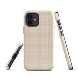 A smartphone with a plaid design case is displayed. The durable phone case features a beige and light brown checked pattern. The phone's camera lenses are visible at the top left corner. With dual-layer protection, the bottom of the impact-resistant polycarbonate Sophisticated Plaid for iPhone case reads "Statement Cases" in white.