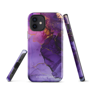 A Statement Cases Golden Orchid Marble for iPhone with a case featuring an abstract design of swirling purple, pink, and gold hues over a white background. The marbled patterns with metallic accents provide dual-layer protection and are impact-resistant. The top of the case has cutouts for the phone's camera lenses and is induction charging compatible.