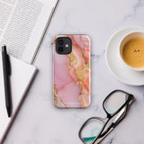 The Gold Blush Marble for iPhone showcases a glossy, marble-patterned case in shades of pink and gold. The decorative design features swirling patterns, seamlessly blending the colors. Crafted with impact-resistant polycarbonate for superior phone protection, "Statement Cases" is written in white at the bottom.