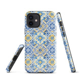 The Blue Mirage for iPhone by Statement Cases features a dual-layered, impact-resistant polycarbonate exterior with a TPU inner liner. Inspired by traditional Portuguese tiles, the blue and yellow patterned case boasts an intricate design of floral and geometric motifs. With its elegant and colorful appearance, the phone's camera is visible at the top left of the case.