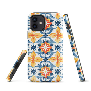 Statement Cases' Mediterranean Bloom for iPhone is showcased, featuring an intricate, colorful pattern. The design includes blue, yellow, and orange floral shapes in a symmetrical arrangement on a light blue background. This durable phone case provides dual-layer protection and is constructed from impact-resistant polycarbonate to safeguard your device.