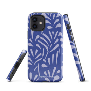 An iPhone encased in the "Mariposa Azul" by Statement Cases, featuring a blue design with an abstract white leaf pattern. The case combines curved and pointed shapes and provides dual-layer protection with TPU lining and impact-resistant polycarbonate. Camera lenses and other top elements remain unobstructed, and "Statement Cases" is inscribed at the bottom.