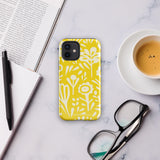 The Sol Dorado for iPhone by Statement Cases is a smartphone with a yellow case featuring a white, abstract floral and plant pattern. The camera lenses are prominent in the top left corner of the device. With dual-layer protection and impact-resistant TPU lining, "Statement Cases" is printed at the bottom of the case.