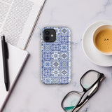 The Lisboa Azul for iPhone by Statement Cases is a smartphone adorned with a dual-layer protection phone case, featuring an intricate blue and white tile pattern. The design showcases various geometric and floral motifs, forming a visually appealing mosaic effect. The impact-resistant camera lenses and flash are prominently visible at the top left.