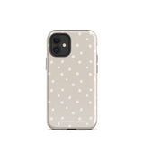 A beige Classic Nude for iPhone case with white polka dots, designed for the iPhone 15 Pro Max, covering the back of a phone with three visible camera lenses and one flash positioned at the upper left corner. This protective iPhone case features "Statement Cases" in small capital letters at the bottom.