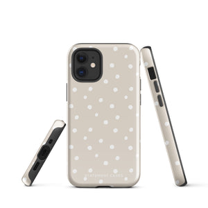 A beige Classic Nude for iPhone case with white polka dots, designed for the iPhone 15 Pro Max, covering the back of a phone with three visible camera lenses and one flash positioned at the upper left corner. This protective iPhone case features "Statement Cases" in small capital letters at the bottom.