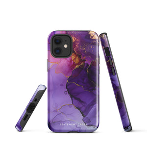 A Statement Cases Golden Orchid Marble for iPhone with a case featuring an abstract design of swirling purple, pink, and gold hues over a white background. The marbled patterns with metallic accents provide dual-layer protection and are impact-resistant. The top of the case has cutouts for the phone's camera lenses and is induction charging compatible.