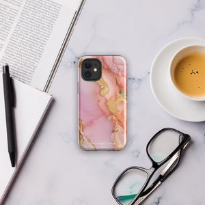 The Gold Blush Marble for iPhone showcases a glossy, marble-patterned case in shades of pink and gold. The decorative design features swirling patterns, seamlessly blending the colors. Crafted with impact-resistant polycarbonate for superior phone protection, "Statement Cases" is written in white at the bottom.