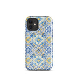 The Blue Mirage for iPhone by Statement Cases features a dual-layered, impact-resistant polycarbonate exterior with a TPU inner liner. Inspired by traditional Portuguese tiles, the blue and yellow patterned case boasts an intricate design of floral and geometric motifs. With its elegant and colorful appearance, the phone's camera is visible at the top left of the case.