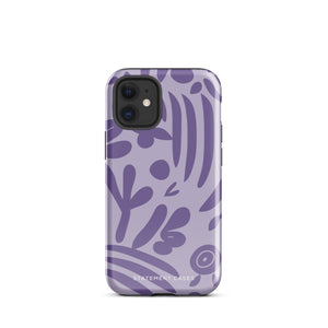 The Luna Morada for iPhone by Statement Cases is a durable phone case with a purple protective exterior featuring abstract dark purple and lavender patterns. The design includes geometric shapes and curves, giving it a modern artistic look. Made from impact-resistant polycarbonate, the lower part of the case prominently displays "STATEMENT CASES.