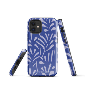 An iPhone encased in the "Mariposa Azul" by Statement Cases, featuring a blue design with an abstract white leaf pattern. The case combines curved and pointed shapes and provides dual-layer protection with TPU lining and impact-resistant polycarbonate. Camera lenses and other top elements remain unobstructed, and "Statement Cases" is inscribed at the bottom.