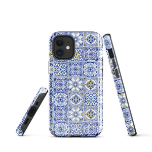 The Lisboa Azul for iPhone by Statement Cases is a smartphone adorned with a dual-layer protection phone case, featuring an intricate blue and white tile pattern. The design showcases various geometric and floral motifs, forming a visually appealing mosaic effect. The impact-resistant camera lenses and flash are prominently visible at the top left.