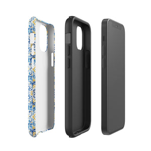 The Blue Mirage for iPhone by Statement Cases features a dual-layered, impact-resistant polycarbonate exterior with a TPU inner liner. Inspired by traditional Portuguese tiles, the blue and yellow patterned case boasts an intricate design of floral and geometric motifs. With its elegant and colorful appearance, the phone's camera is visible at the top left of the case.